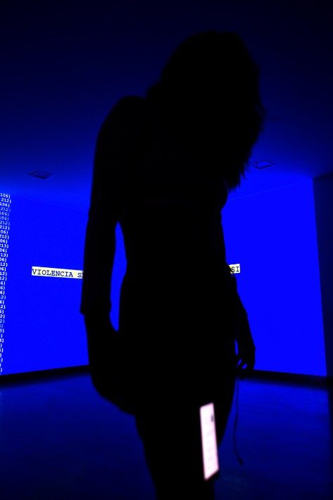 The performer silhouetted against a blue projection during the OnChange() performance.